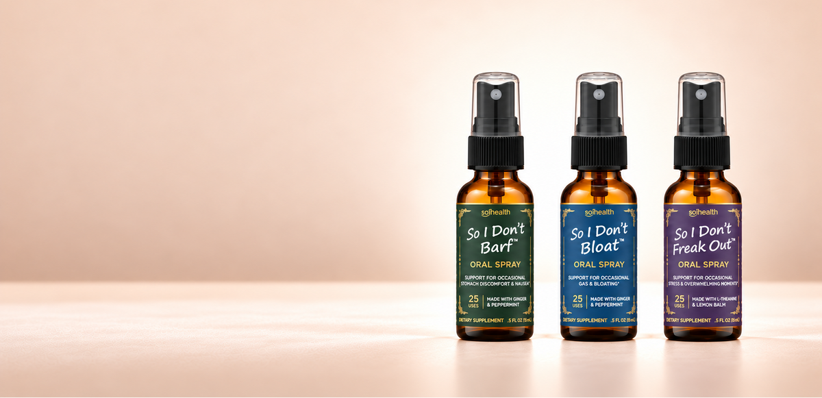 Three amber spray bottles of So I Don't Barf, So I Don't Bloat, and So I Don't Freak Out Oral Mist lined up on a warm beige background. The bottles have black sprayers and labels in dark green, navy blue, and purple with white text.